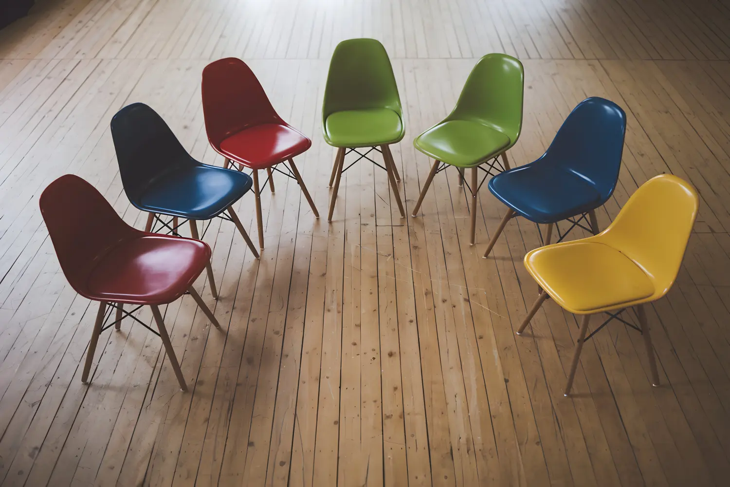 Bunte Stühle im Halbkreis, lebendiges, integratives Gemeinschaftsambiente